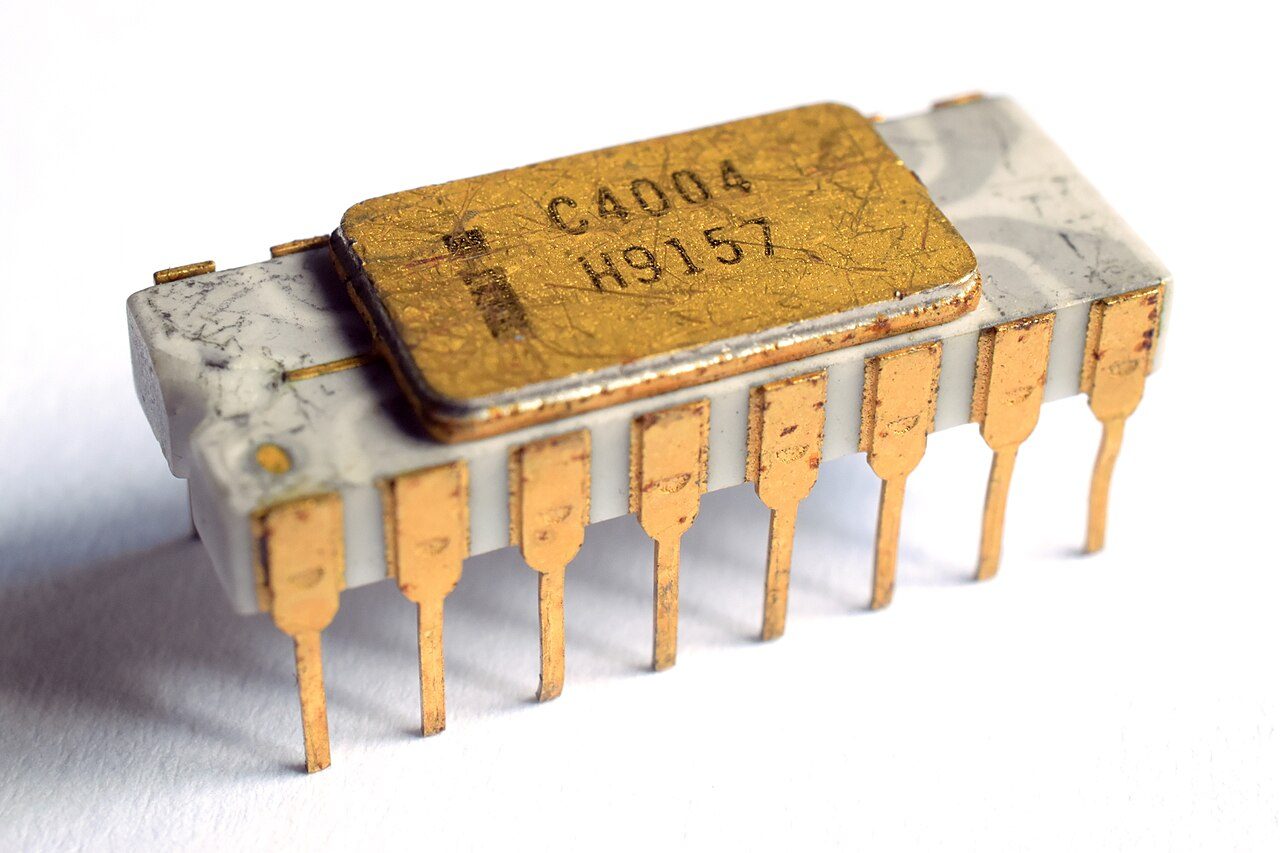 An Intel C4004 microprocessor: a white ceramic package with a gold lid marked C4004 and sixteen gold pins