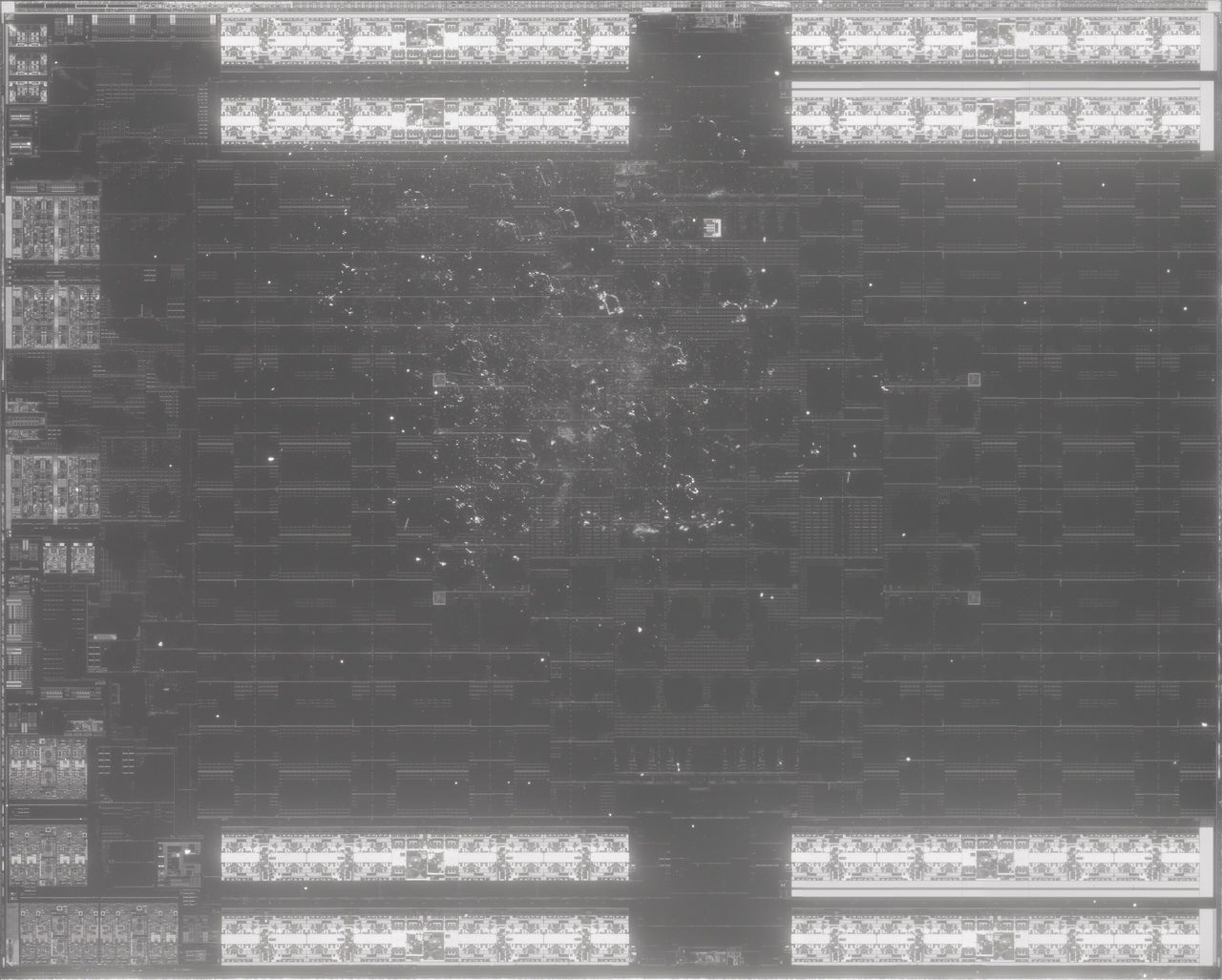 Near-infrared photograph of the Navi 10 die in shades of grey: four bright rectangular bands along the top edge and four along the bottom, a column of varied blocks down the left edge, and a large dark area of faint repeated structure filling the middle