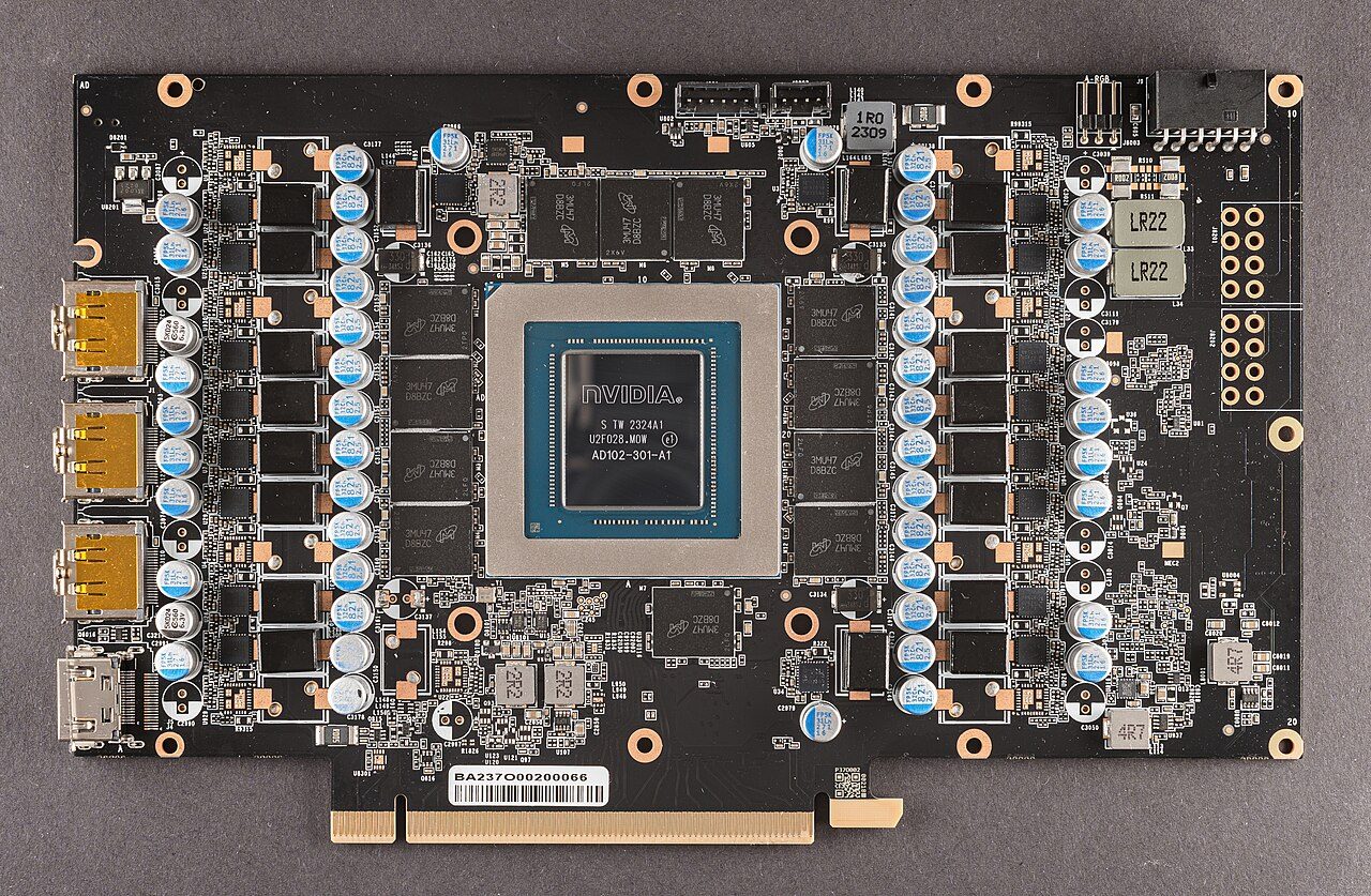 An RTX 4090 circuit board with its cooler removed: the AD102 chip in the centre, twelve memory chips around it, and columns of capacitors and inductors on either side